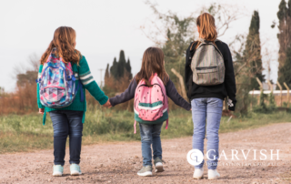 Three Children walking away with backpacks