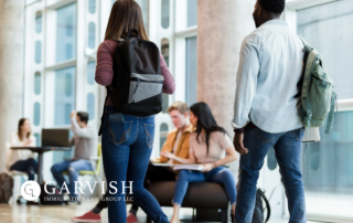 College Students walking through hallway with backpacks