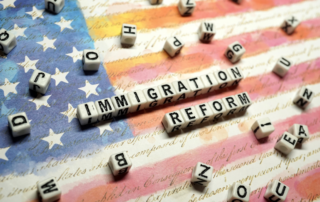 Scrabble letters spelling out the words immigration reform. American flag artwork in the background.