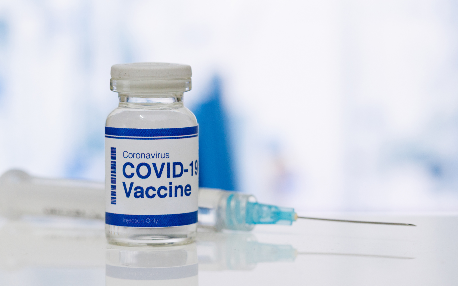 covid-19 vaccine in a bottle with a syringe behind it. Coronavirus COVID-19 Vaccine in a lab.