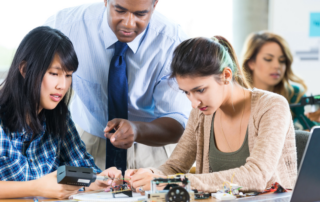 Blog Header, Stock Photo of International University Students working with professor on a STEM or robotics project