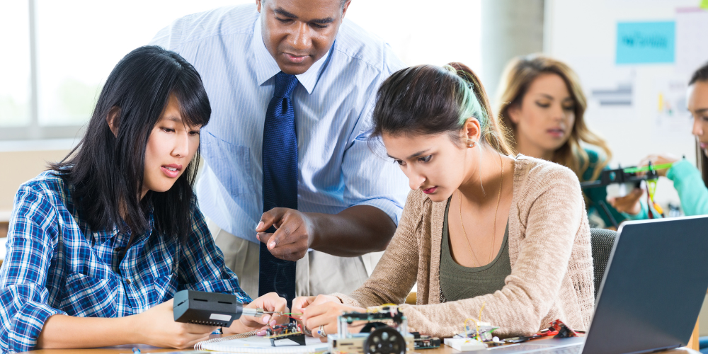 Blog Header, Stock Photo of International University Students working with professor on a STEM or robotics project